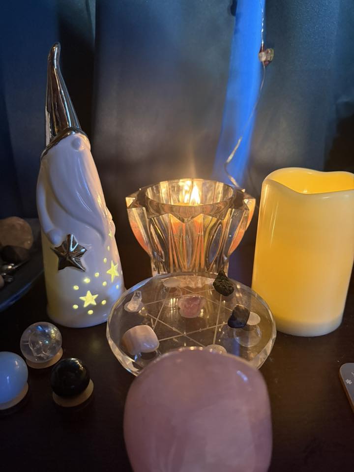 Photo of a collection of tchotchkes on a table with two candles.