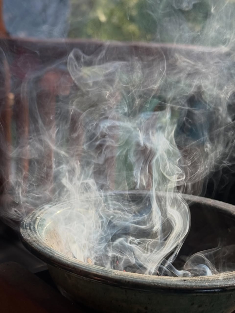 Photo of a large cauldron with light smoke rising from its bottom area